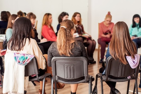 group of people sitting in chairs in a circle